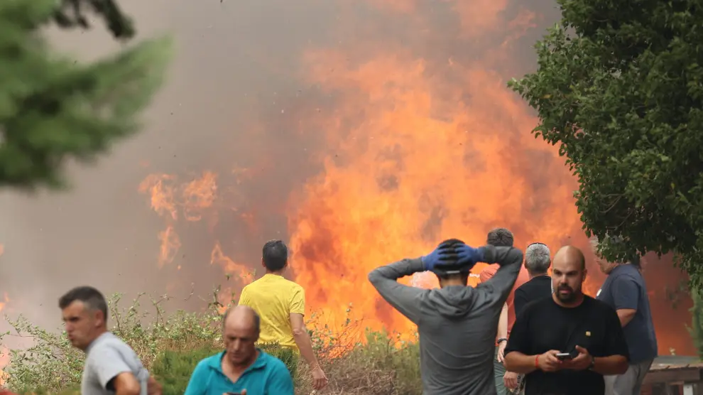 Vecinos de la localidad luchan contra las llamas del incendio.