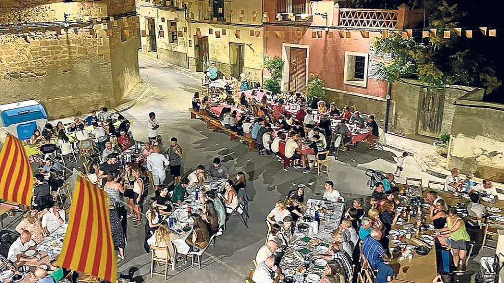 Los vecinos en la cena popular de las fiestas, que celebran para  el 15 de agosto.