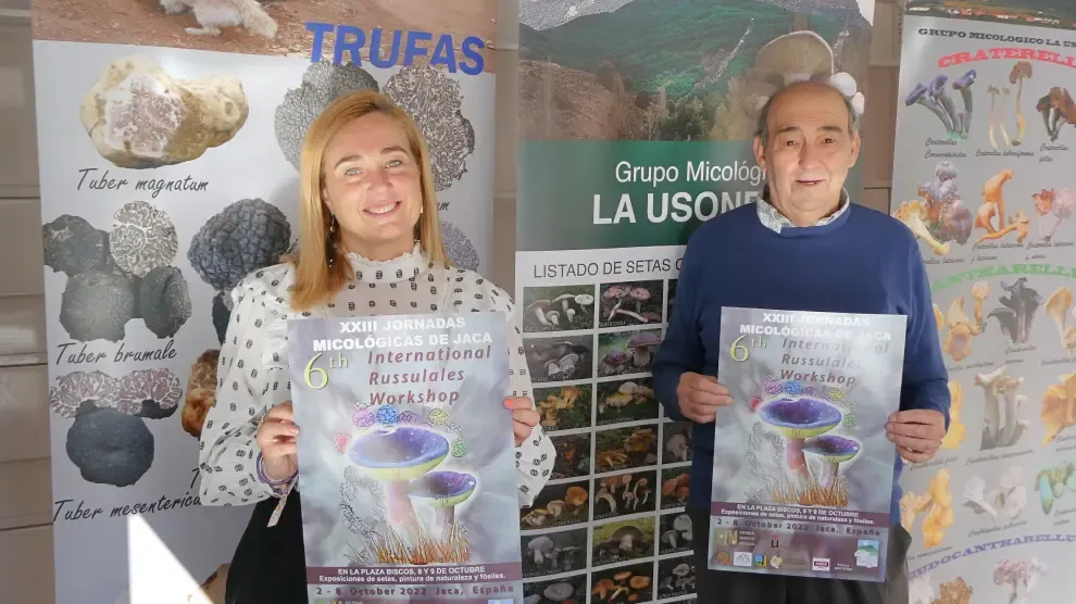 Olvido Moratinos y Joaquín Fernández muestran el cartel del doble evento micológico en la plaza Biscós.