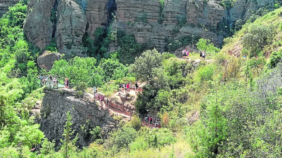 Turistas recorriendo un tramo de la Ruta de Pasarelas en el barranco del río Vero en Alquézar.