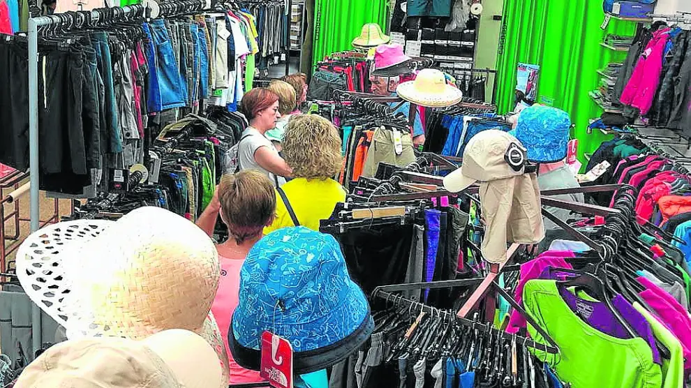 Varios clientes revisan la ropa disponible en el outlet de la empresa oscense Casbas enla población de Bolea.