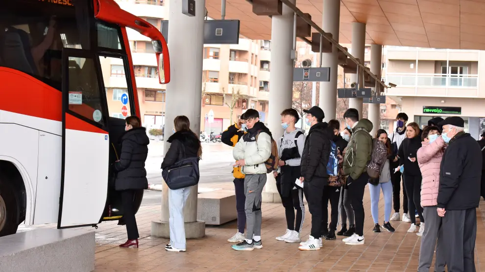 Usuarios del transporte público utilizan la mascarilla antes de entrar al autobús.