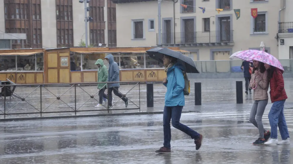 Vecinos de Jaca con paraguas esta sábado, por las calles de la localidad.