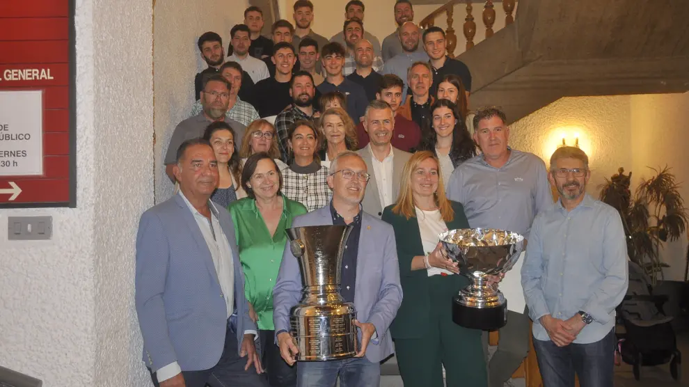 Foto de familia de los deportistas y las autoridades, con los trofeos de la Liga y la Copa del Rey de hockey sobre hielo.