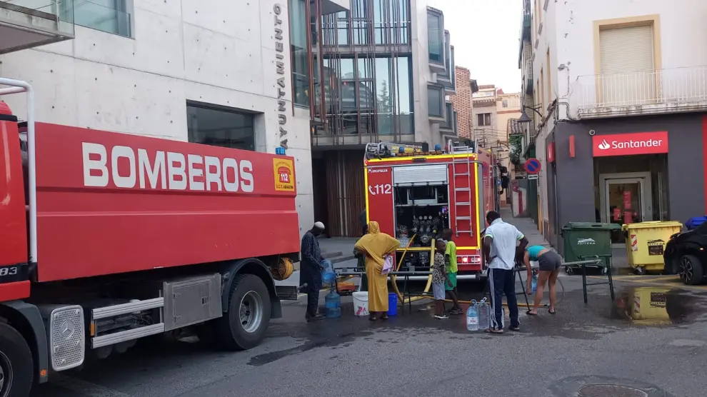 Vecinos acuden a un camión de bomberos para obtener agua tras la avería registrada en Binéfar.