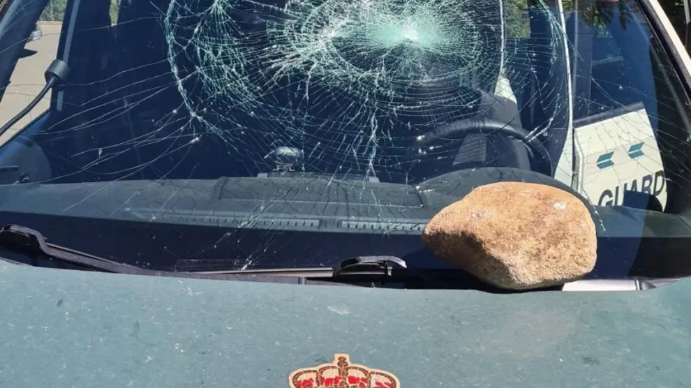 Vehículo de la Guardia Civil dañado por la piedra.