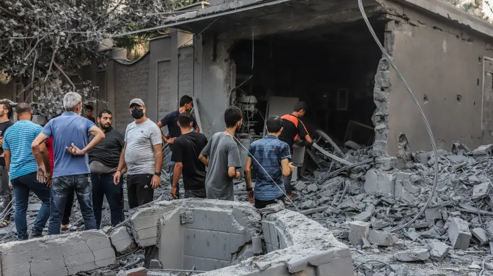 Un grupo de palestinos comprueban los destrozos sufridos tras un ataque israelí.