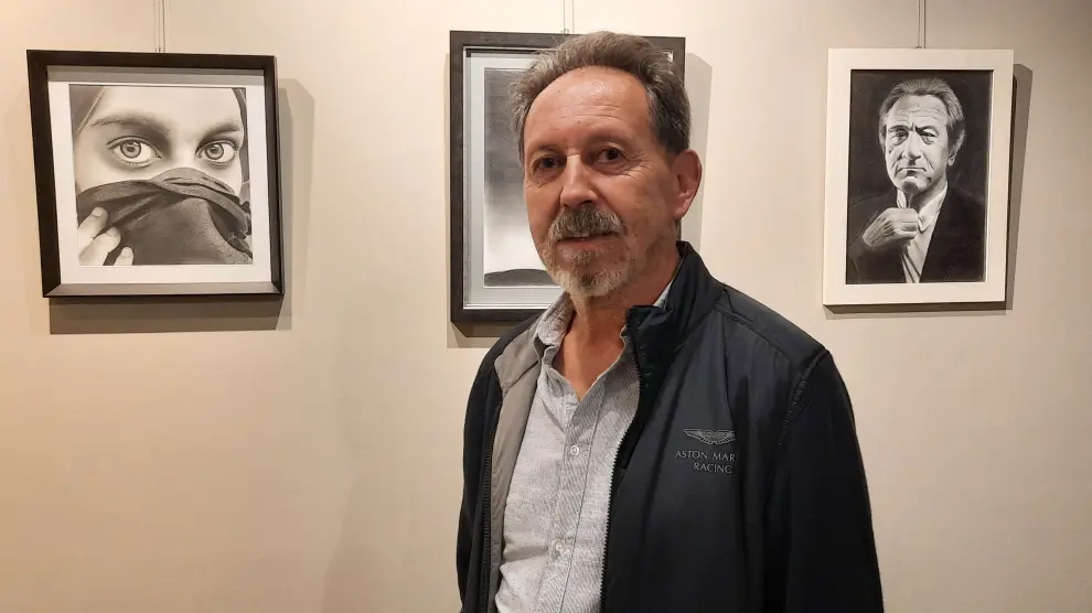 Eduardo Rivera delante de algunos de los dibujos a carboncillo que expone en Casa Heredia.
