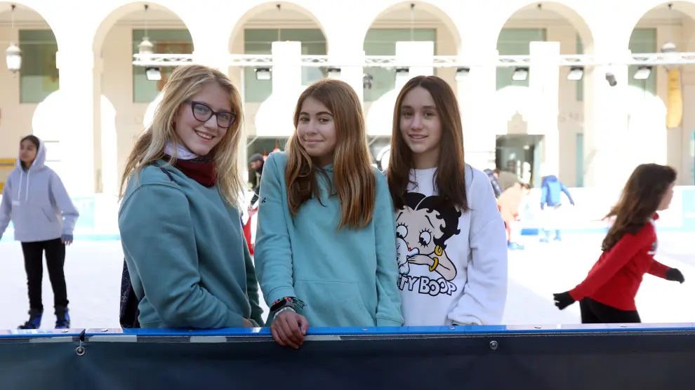 Jóvenes participan del programa 'Vacaciones por Navidad' en la pista de patinaje sobre hielo en la plaza López Allué