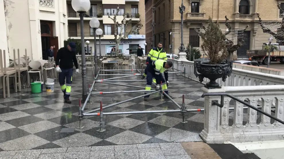 Operarios del Ayuntamiento de Huesca instalando una estructura para el espectáculo que dará la bienvenida a los Reyes Magos.