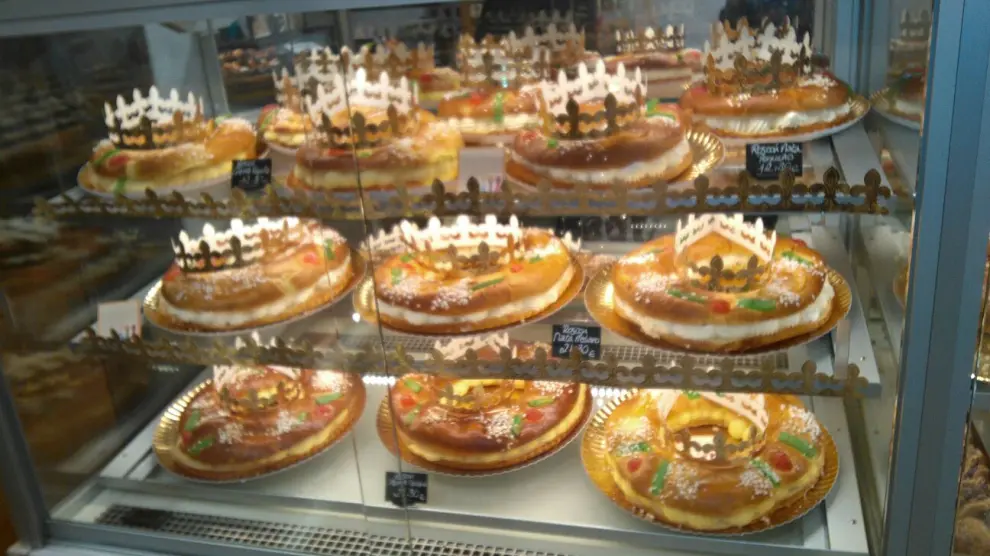 Vitrina de la pastelería con roscones con distintos rellenos y cada uno con su corona listos para salir a la venta.
