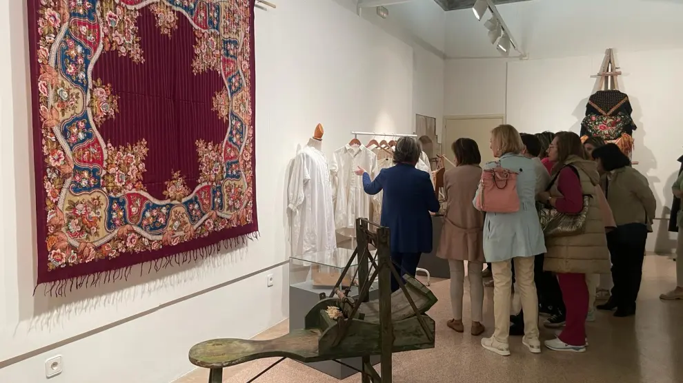 Un grupo de visitantes observan prendas de hilo en la exposición inaugurada este jueves en Fraga.