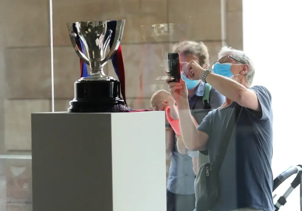 Los aficionados se hacen fotos con la copa del Huesca.