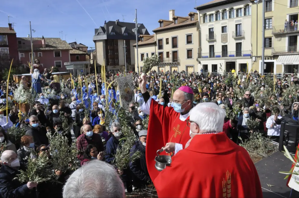 El obispo de Jaca y Huesca, Julián Ruiz, bendice las palmas y los ramos de las personas congregadas en la plaza Biscós de Jaca durante el Domingo de Ramos.