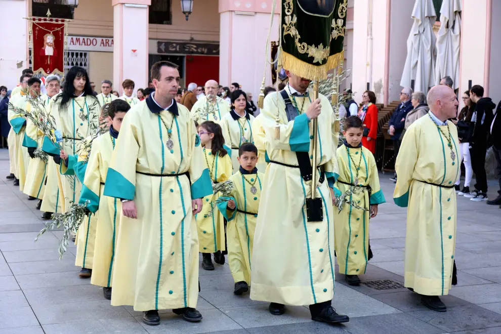 Jesús llega triunfal a Jerusalén entre palmas y brotes de olivo acompañado por cofrades de todas las edades.