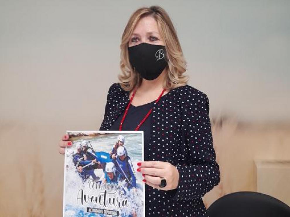 Beatriz Calvo muestra el cartel de la actividad Comarca Aventura 2021.