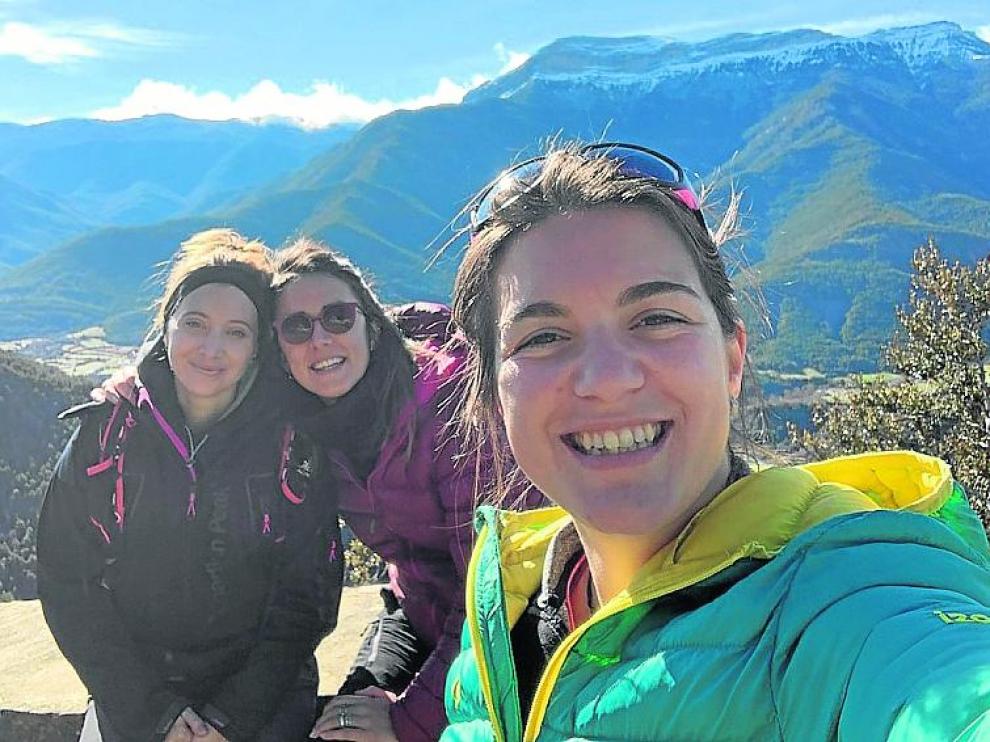 Alba Pueyo, Elena Jal y Ainhoa Viñuales posan con Fiscal y la Peña Canciás al fondo