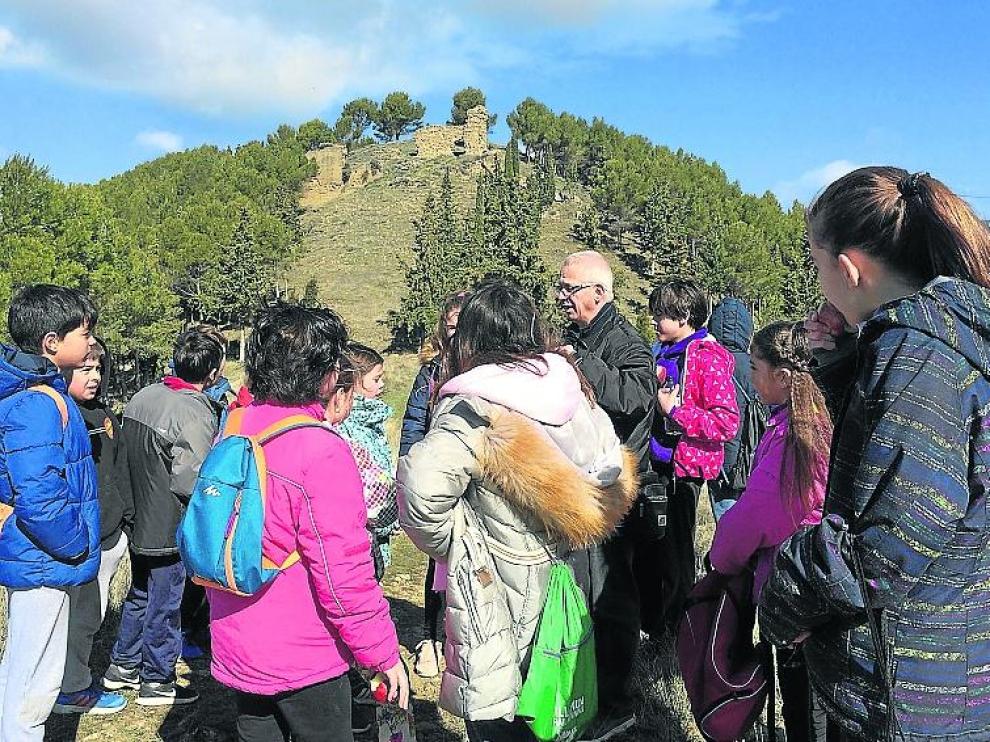 Chesús Jiménez explica a un grupo de escolares las ruinas del antiguo castillo de Ayerbe
