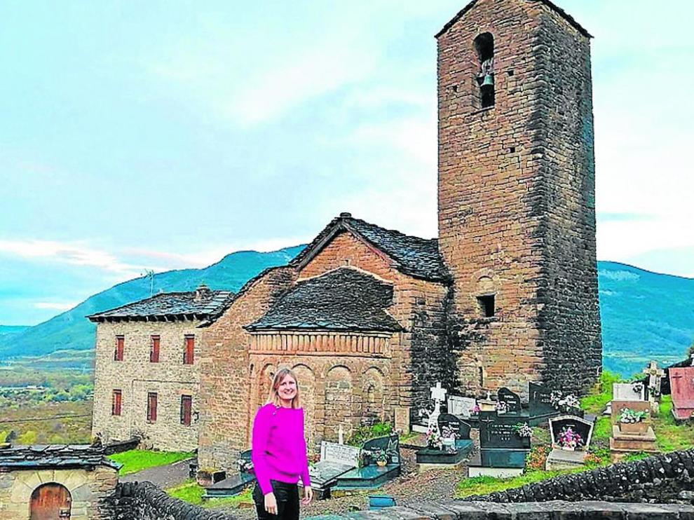 Mónica Ara, directora de la oficina de Caja Rural de Aragón en Jaca junto a la iglesia de su pueblo: Oliván