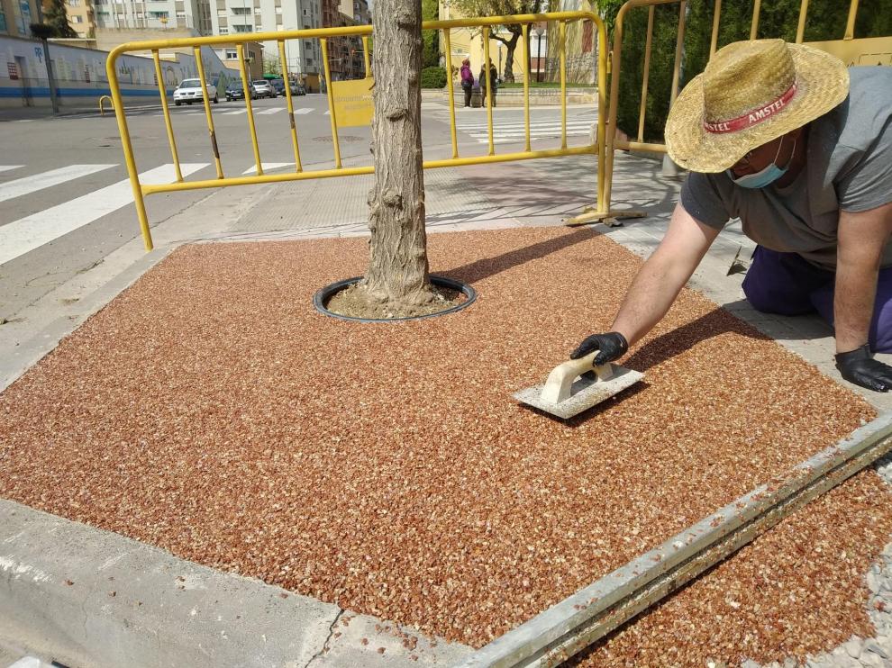 Un operario coloca materiales permeables en los alcornoques.