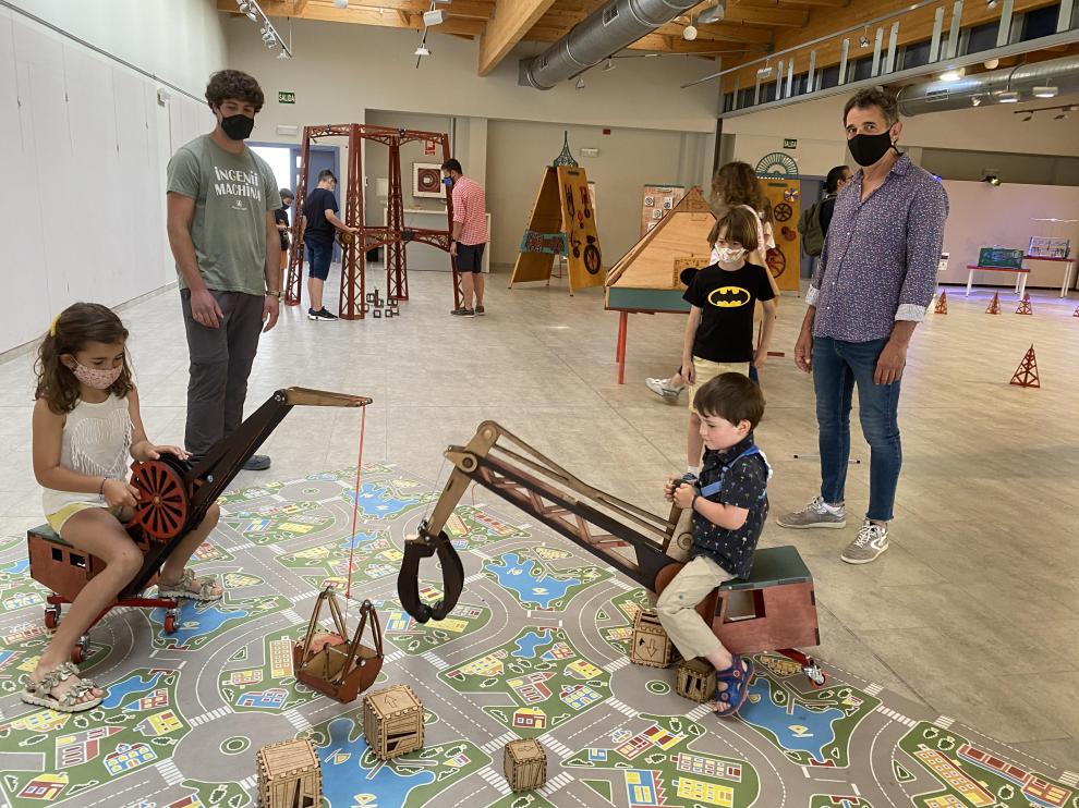 Los niños pueden desplazar cubos de madera con dos grúas de juguete.