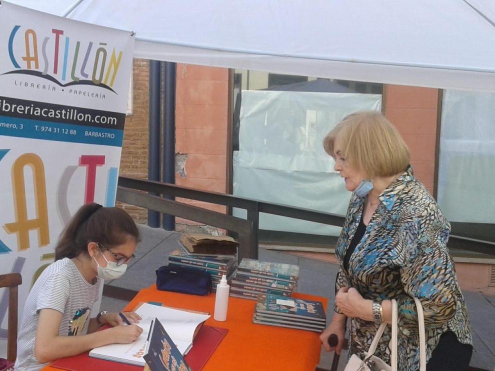 La autora Irene Mora Borruel, firmando varios ejemplares a los barbastrenses.