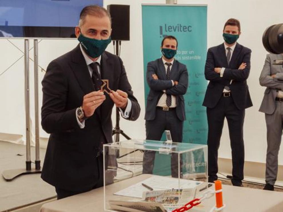El presidente de Levitec Huesca da una palada en la puesta de la primera piedra de la instalación.