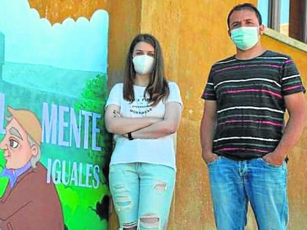 La artista María Salinas junto al alcalde de Lascuarre, José Luis Lloret, junto al mural pintado en el casco urbano.