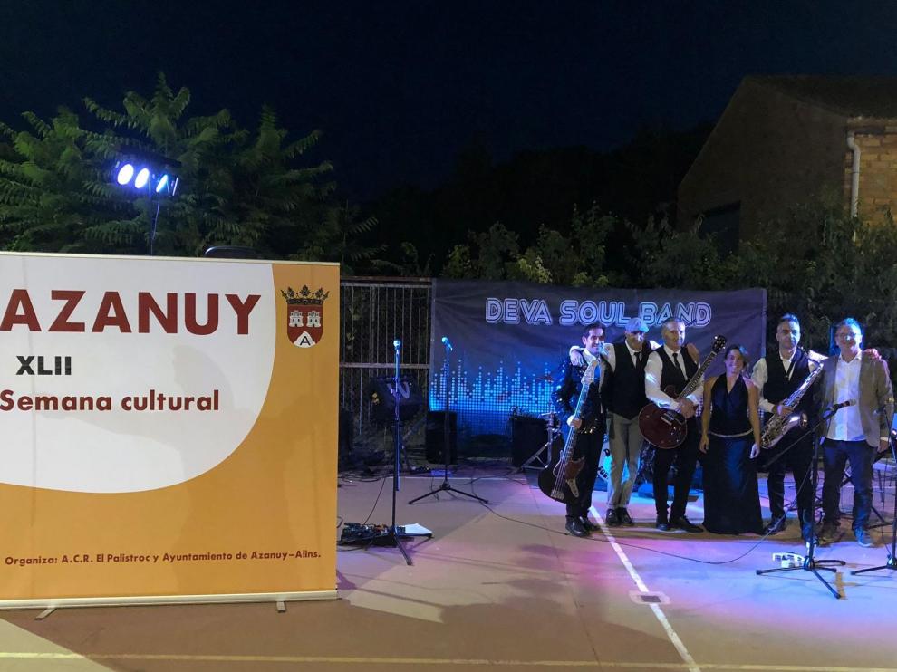 En la imagen, los miembros de Deva Soul Band junto al cartel de las jornadas culturales.