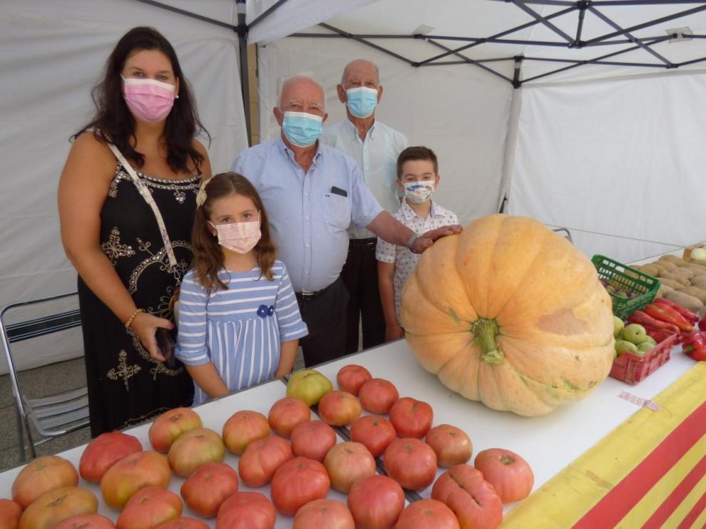 Tres generaciones de la familia Larrosa en torno a la calabaza de 65 kilos, premiada.