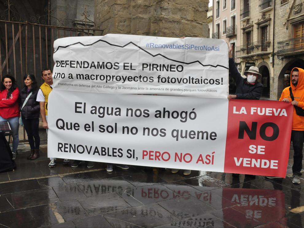 Representantes de las diferentes plataformas comarcales mostraron pancartas contra los macroparques solares a las puertas de la Catedral de Jaca.