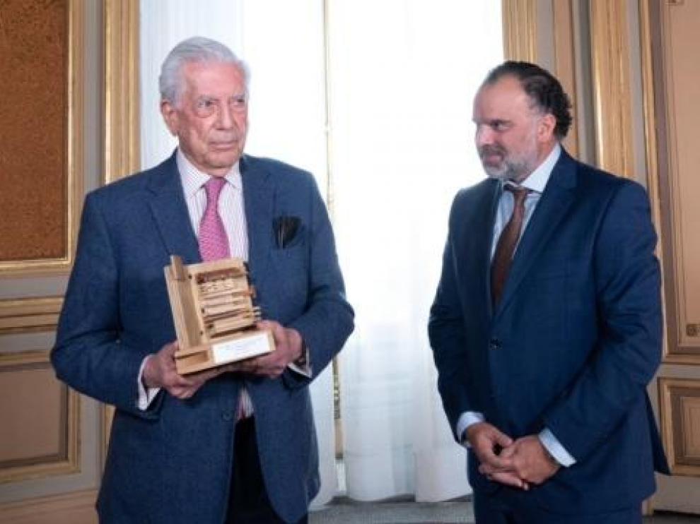 Vargas Llosa muestra el premio que le ha recibido de manos de Fernando de Yarza.