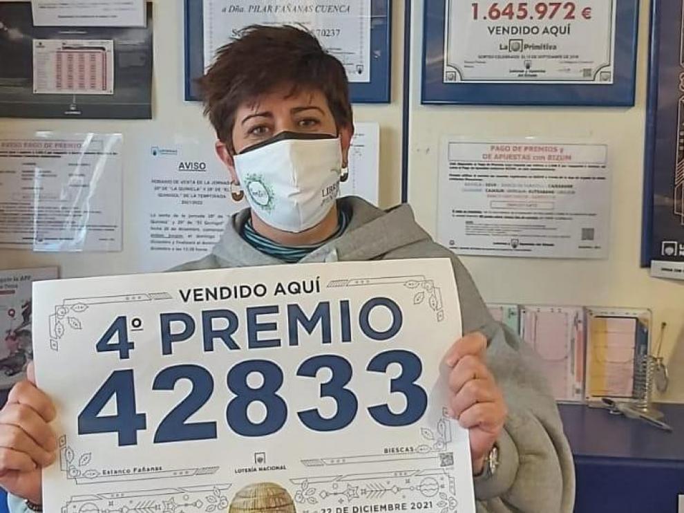 María Pilar Fañanás muestra el cartel de loterías con el número premiado.