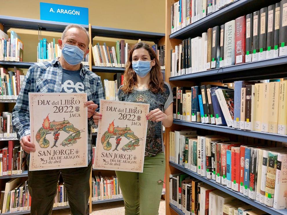 Los concejales de Cultura, Javier Acín, y de Juventud, Laura Climente, con el cartel del programa del Día del Libro, en la Biblioteca de Jaca.