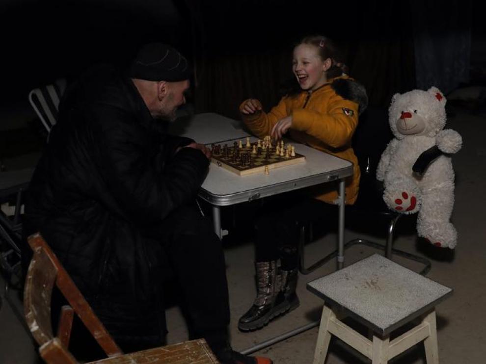 Una niña sonríe y juega al ajedrez, junto a su peluche, en el refugio en el que se esconde de los ataques. UKRAINE RUSSIA CONFLICT