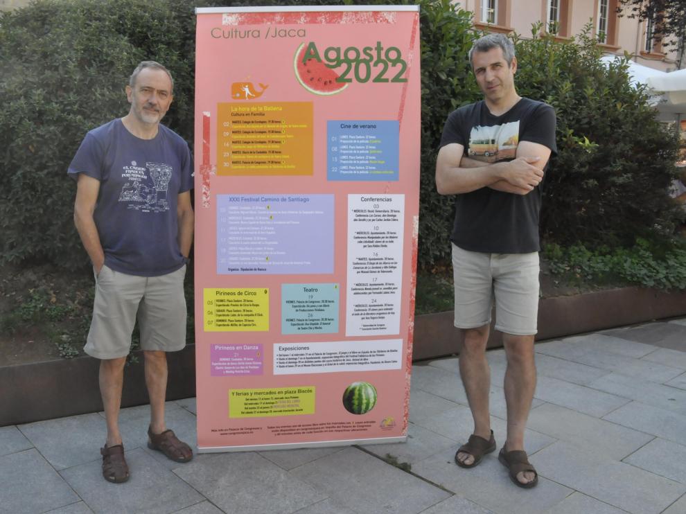 Javier Acín y Jorge Mur, en la plaza Biscós, junto a la programación cultural del Consistorio jaqués para el mes de agosto.