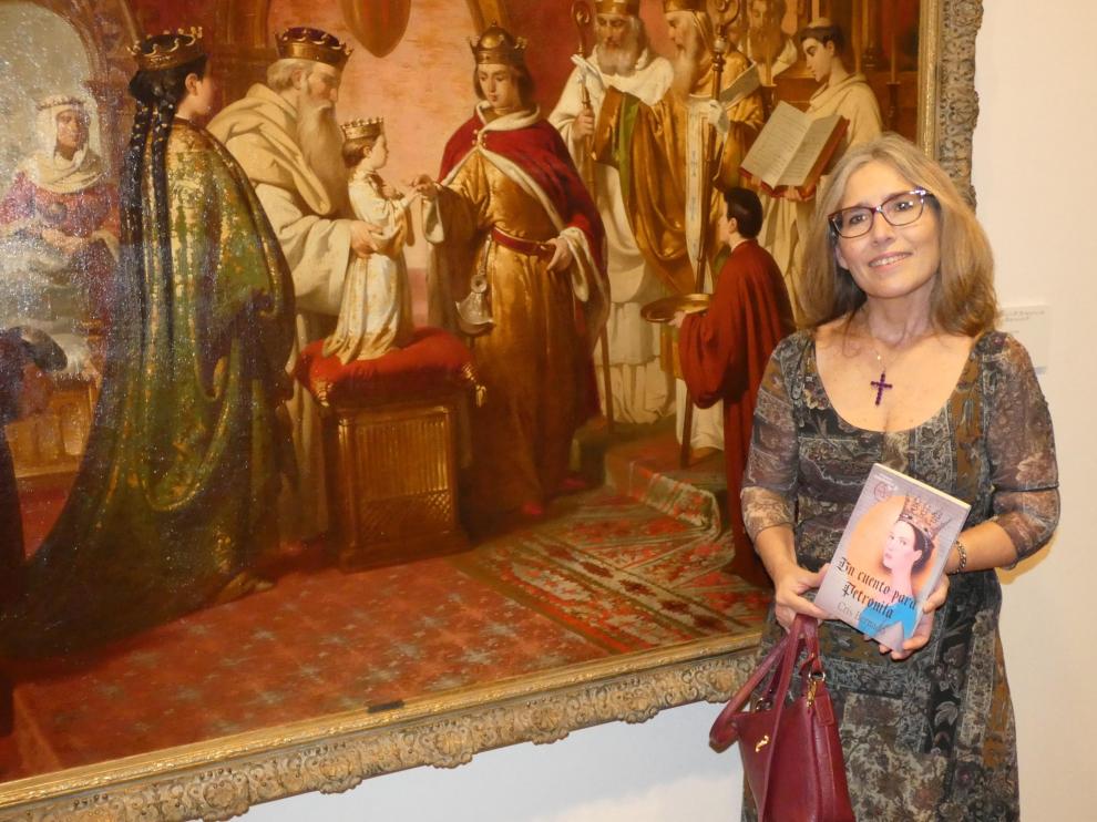 Cris Bernadó con el libro y ante el óleo de los Esponsales de Petronila, en el Museo Diocesano.
