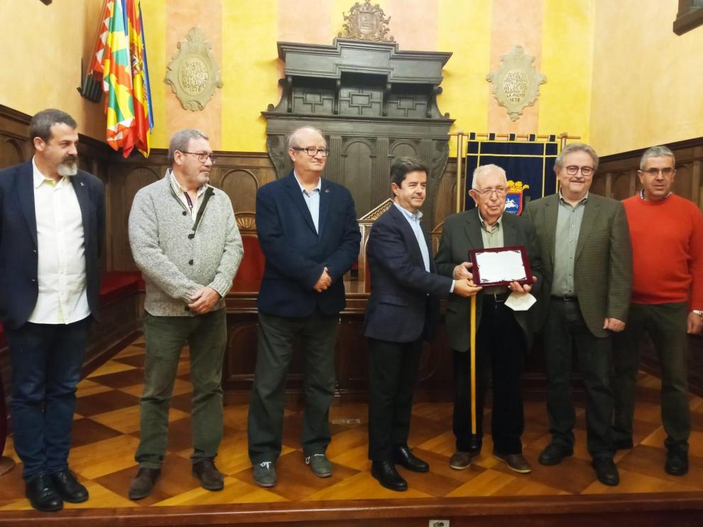 Mariano Carrera recibe de manos del alcalde de Huesca la placa que reconoce la labor de su familia.