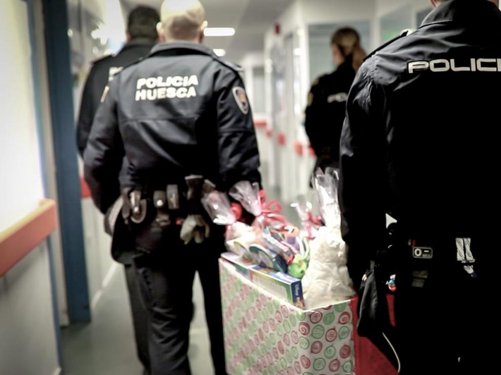 Agentes de Policía Local y Nacional de Huesca llevan los primeros regalos de Reyes a los niños del Hospital San Jorge