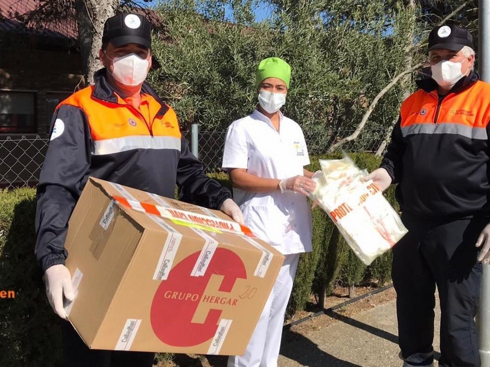 Protección Civil del Somontano reparte batas biodegradables para la protección ante el coronavirus por varios centros