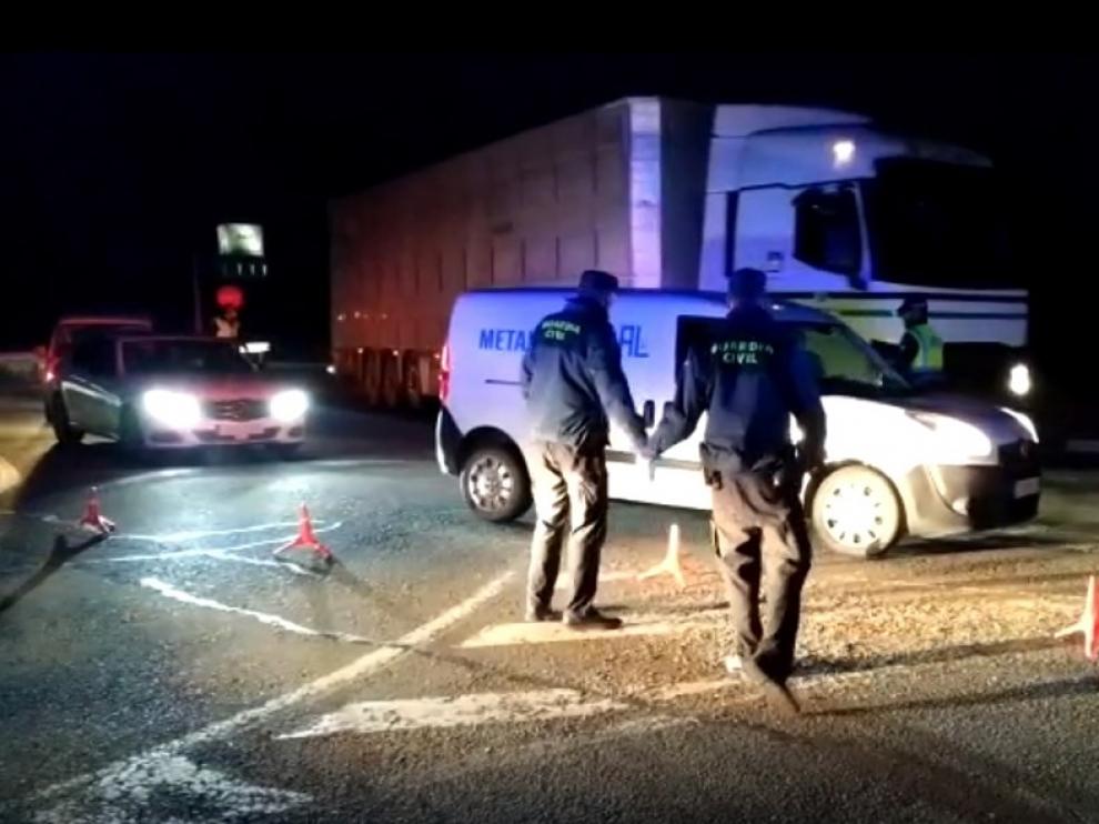 Agentes de la Guardia Civil de Fraga reparten desde la madrugada mascarillas a personal de transporte