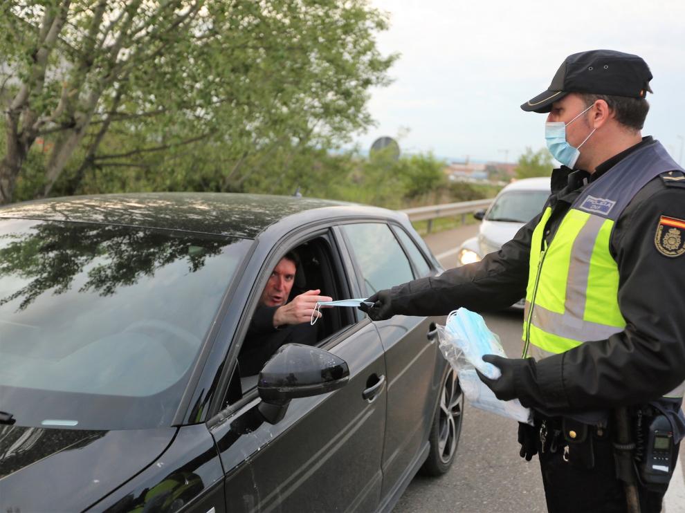 Policía y Protección Civil reparten mascarillas a los oscenses que iban a trabajar