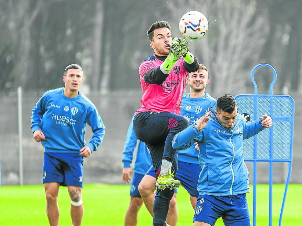 Álvaro Fernández despeja de puños en el entrenamiento del Huesca ayer.