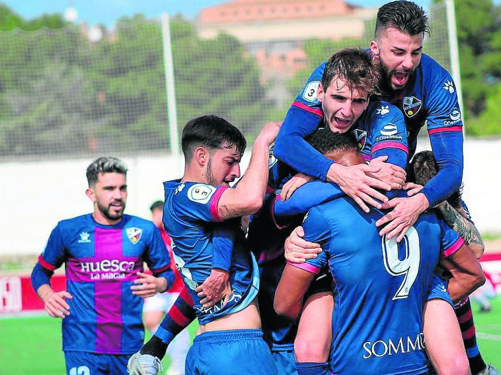 Los jugadores del Huesca B se abrazan con Carlos Kevin tras marcar el gol de la victoria.