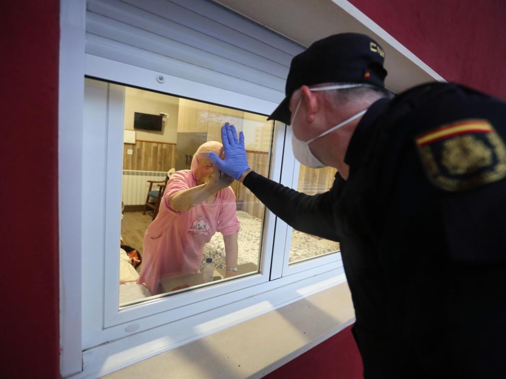Un policía anima a una anciana en la residencia Los Olivos de Huesca, en la primera ola.