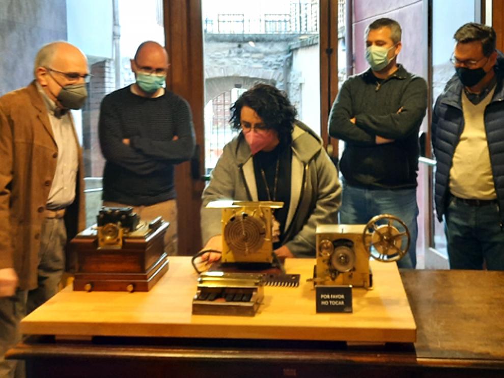 Asistentes a la inauguración observan la pieza más valiosa de la muestra, un antiguo telégrafo.