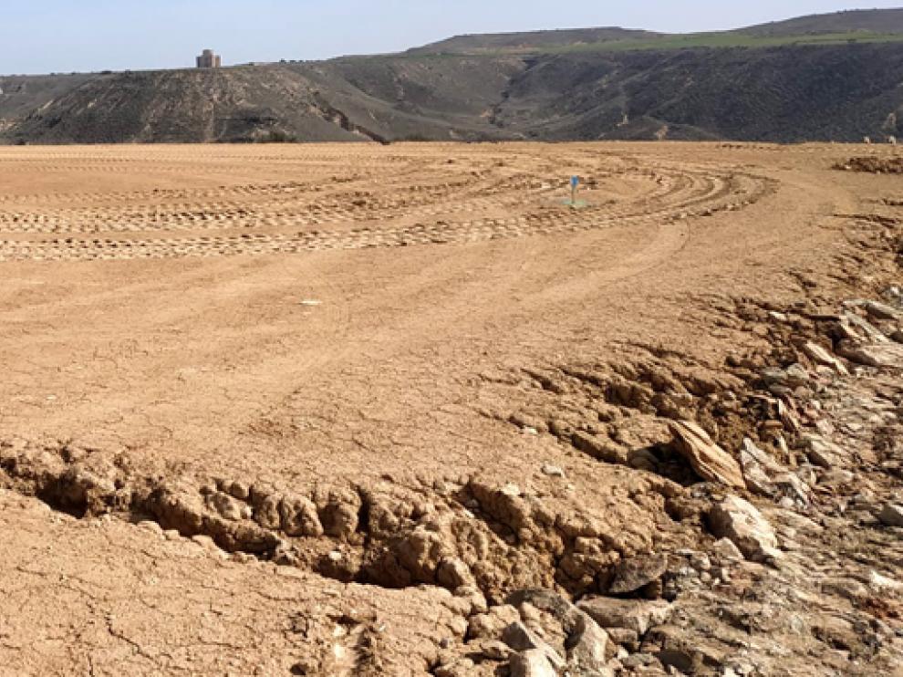 Imagen de un terreno con la ermita de Chalamera al fondo.