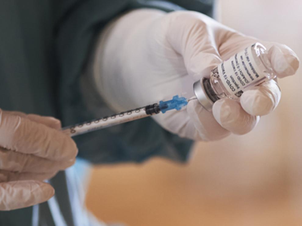 Una profesional sanitaria sostiene un vial con la vacuna de AstraZeneca