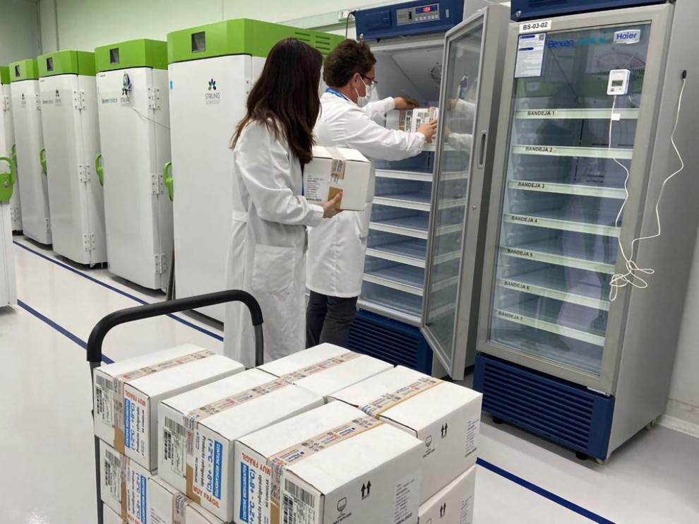 Dos técnicos meten en cámaras frigoríficas las vacunas de AstraZeneca distribuidas por el Ministerio de Sanidad.