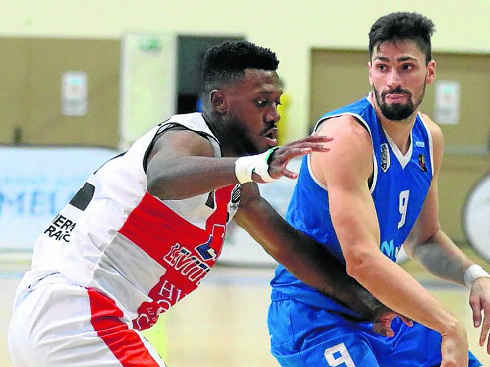 Mike Moore, defendiendo en Melilla, es el indicado para frenar el juego en el poste bajo de Cáceres de Barber y Schaftenaar.